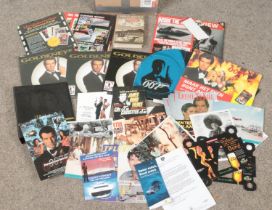 A box of James Bond ephemera. Includes magazines, lobby cards, Ian Fleming Thrilling Cities book,