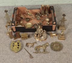 A box of novelty brassware to include figure of a gentlemen, seal, love spoons, candlesticks, shoes,