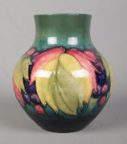 A Moorcroft pottery vase decorated in the Leaves and Berries design. Signed to base. Height 13.