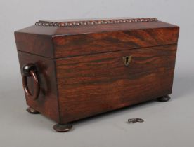 A 19th century rosewood tea caddy of sarcophagus form. Having twin loop handles, fitted interior