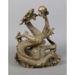 A cast bronze sculpture of a Chinese dragon holding a flaming pearl. Height 18cm.