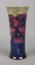 A Moorcroft pottery trumpet shaped vase decorated in the Pansy design. Signed to base. Height