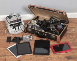 A vintage suitcase containing a variety of cameras and equipment along with bill counter and small