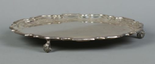 A George VI silver salver with scalloped edge and raised on three scrolled feet. Assayed Sheffield