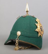 A dark green cloth spiked helmet bearing Connaught Rangers badge.