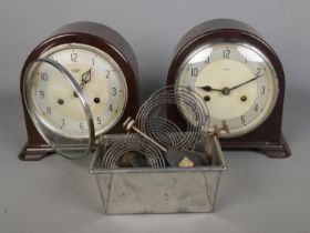 Two Smiths Enfield bakelite cased mantle clocks along with a small collection of clock spares and