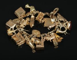 A 9ct gold charm bracelet with floral and paste set links and contents of mostly 9ct gold charms.