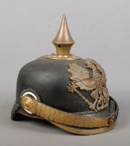 A World War One Imperial German officers pickelhaube bearing eagle badge with motto Mit Gott Fur