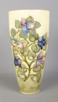 A large Moorcroft pottery vase decorated with flowers. Signed to base. Height 31.5cm. Signs of