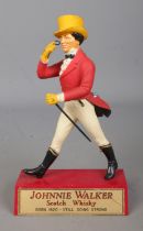 A vintage Johnnie Walker Scotch Whiskey advertising figure. Approx. height 21cm. Crack to plaque.