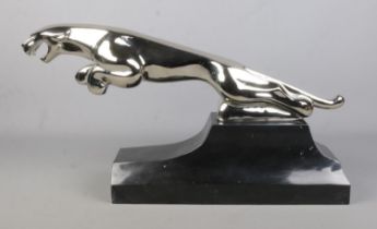 A large cast white metal sculpture of a Jaguar raised on marble base. Length 68cm, Height 34cm.