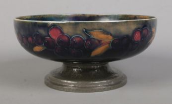 A Moorcroft pottery dish raised on hammered Tudric pewter base. Diameter 19.5cm. Restoration to