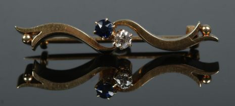 A 15ct gold sapphire and diamond brooch. In case. Length 3.8cm. 5.52g.