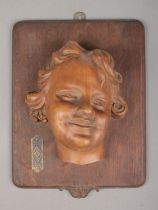 A carved wooden wall plaque of a young girl. The plaque bearing German BDM (League of German