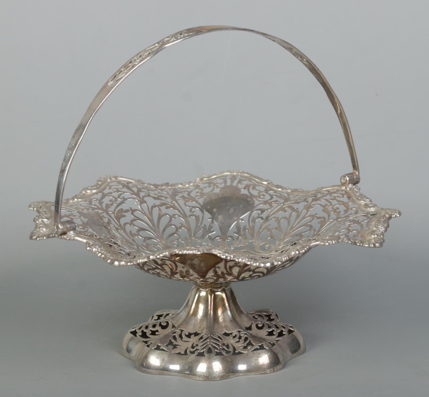 An Edwardian pierced silver basket with swing handle. Assayed Birmingham 1905 by Elkington & Co.