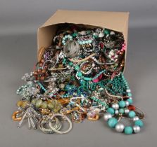 A large box of costume jewellery including various necklaces and bracelets.