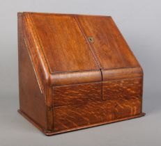 An early 20th century oak desk tidy with fitted interior and perpetual calendar. Height 33cm,
