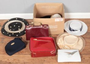 A box of designer handbags and hats. Includes Christian Dior Parfums bag, Estee Lauder, Maylette