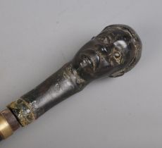 An early 20th century African tribal sword stick with carved bust pommel. Length 94cm. CANNOT POST