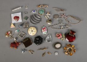 A collection of costume jewellery brooches, pendants and scarf clips to include highland cow,