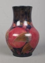 A Moorcroft pottery baluster shaped vase decorated in the Pomegranate design. Signed to base. Height