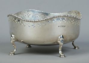 A George V pierced silver bowl raised on four scrolled feet. Assayed Sheffield 1920 by Walker &