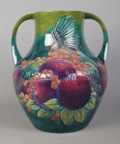 A large Moorcroft pottery twin handled vase decorated in the Finch and Berry pattern. Date cypher