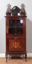 An Edwardian mahogany music cabinet. Having mirrored back, glazed front and inlaid drop down bottom.