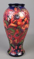 A Moorcroft pottery vase decorated in the flambe design with flowers, butterflies and bees by Emma