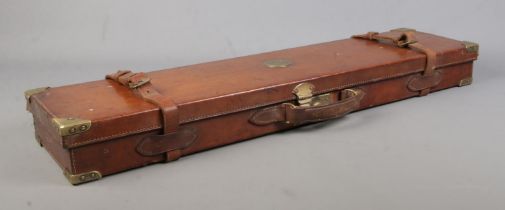 A 19th century leather gun case with fitted interior. Having brass mounts, monogrammed WWK. Length