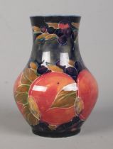 A small Moorcroft pottery baluster shaped vase decorated in the Pomegranate design. Signed to base