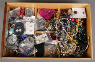 A box of costume jewellery. Includes watches, necklaces, rings, brooches, earrings, etc.