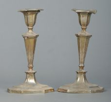 A pair of early 20th century silver candlesticks, raised octagonal stepped bases. Assayed