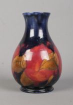 A small Moorcroft pottery baluster shaped vase decorated in the Pomegranate design. Signed to