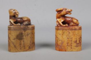 Two 19th century carved soapstone seals, both surmounted with animals, one a water buffalo, the
