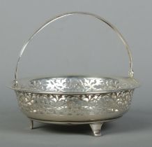 A George V pierced silver swing handle basket raised on three feet. Assayed Birmingham 1915,