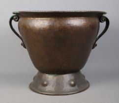 An Arts & Crafts hammered copper twin handled vessel. Height 35.5cm. Some dents and scratches.