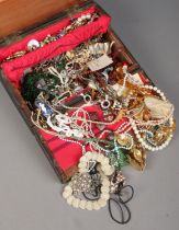 A jewellery boxes with large contents of costume jewellery. Includes beads, rings, necklaces, etc.