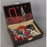 A jewellery case with contents of costume jewellery. Includes amber/copal necklace, coral
