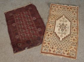 A small red bokhara style rug together with another beige rug and two other examples Bokhara rug