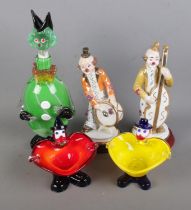 A collection of art glass formed as Murano style clowns to include decanter and two ashtrays along