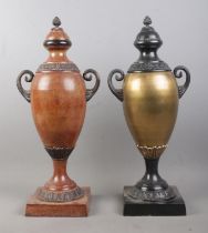 A near pair of bronzed twin handled globular shaped urns, with grape finial and banded floral border