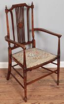 An Edwardian inlaid mahogany salon chair with floral upholstered seat. Split to back rest.
