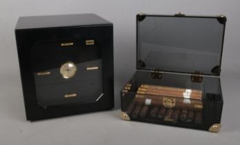 A small matt black humidor by Adorini, can hold up to 100 cigars divided into 3 drawers with a