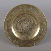 An oriental bronze plate depicting central dragon motif. Character marks to reverse. Approx.