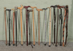 A collection of walking sticks. Includes carved examples with dragon, white metal and abalone, brass
