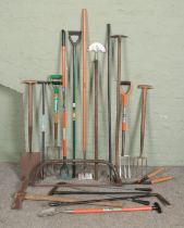 A collection of wood and metal tools, mostly gardening examples.