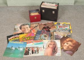 A collection of records in travel case including Beach Boys, Jim Reeves, Benny Hill, Johnny Cash,