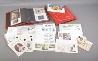 Two empty Benham first day cover albums along with a collection of international first day covers