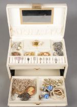A cream leather jewellery box with contents of costume jewellery. Includes rings, filigree brooch,